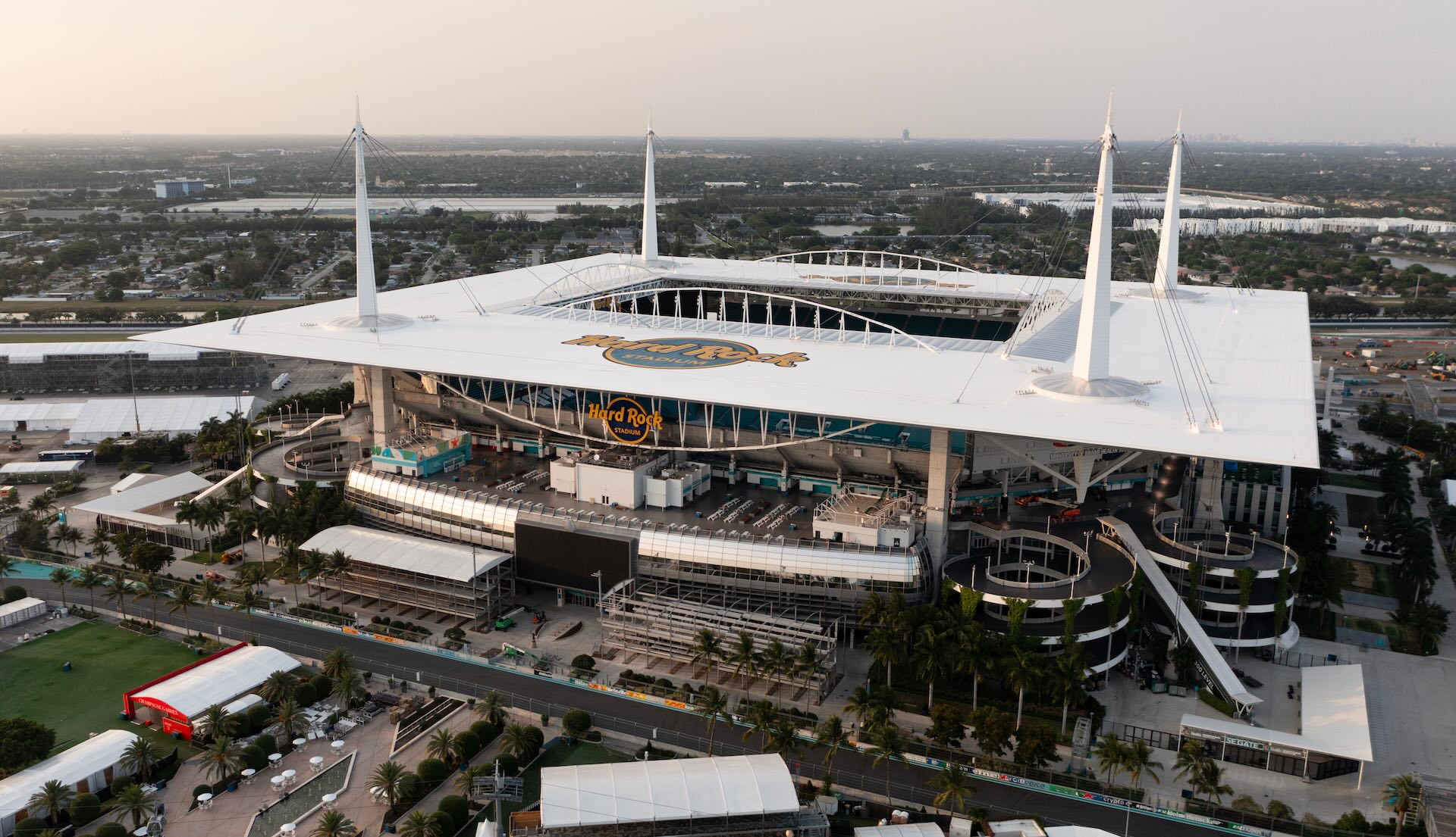 Aerial view of Hard Rock Stadium in Miami, Florida, showing the stadium's white roof, modern design, and surrounding area.