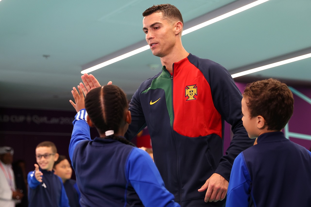 Cristiano Ronaldo Greets Young Fans Before Portugal Match Cristiano Ronaldo in Portugal jacket giving high-fives to young mascots before a football match.