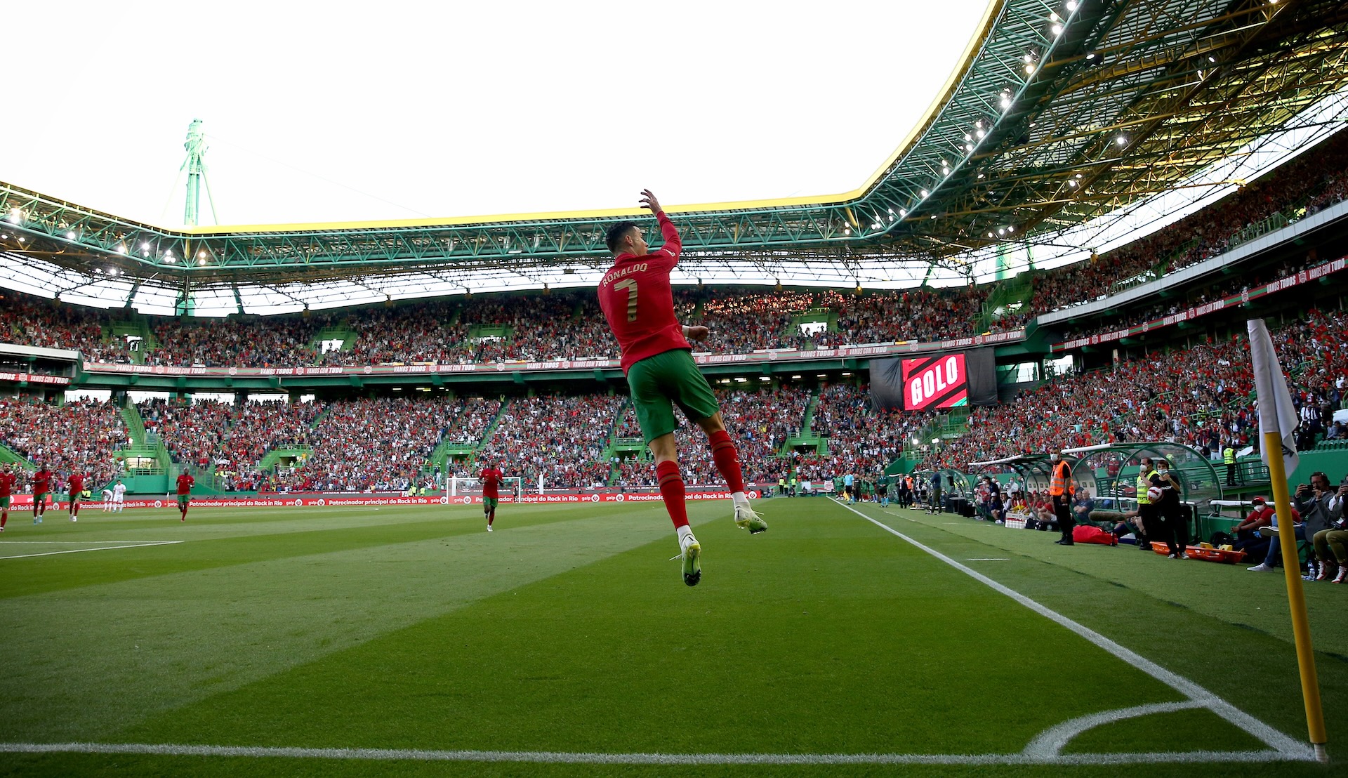 Cristiano Ronaldo jumps in celebration after scoring a goal for Portugal in a stadium full of cheering fans.